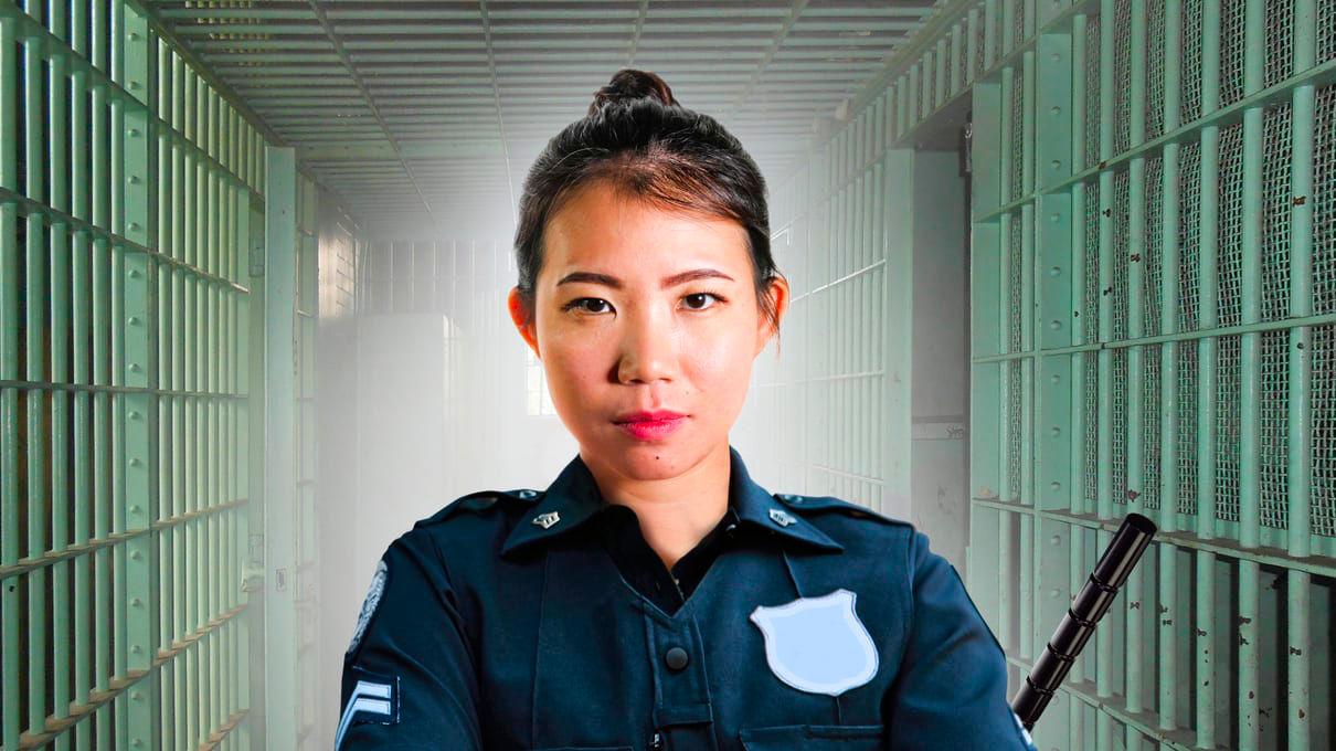 A police officer standing in a jail cell.