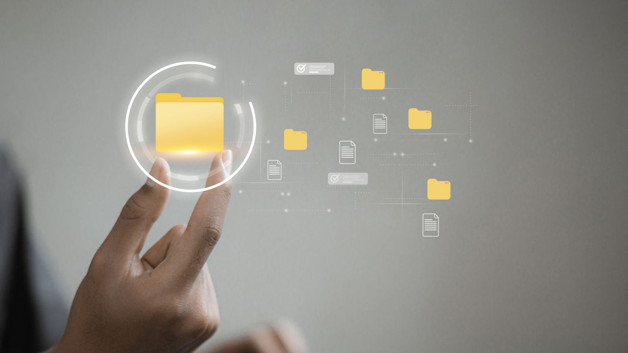 Close up of hand selecting a floating digital folder icon, representing file organization, directory structure, metadata tagging and content management for efficient search, approval and cloud workflow.