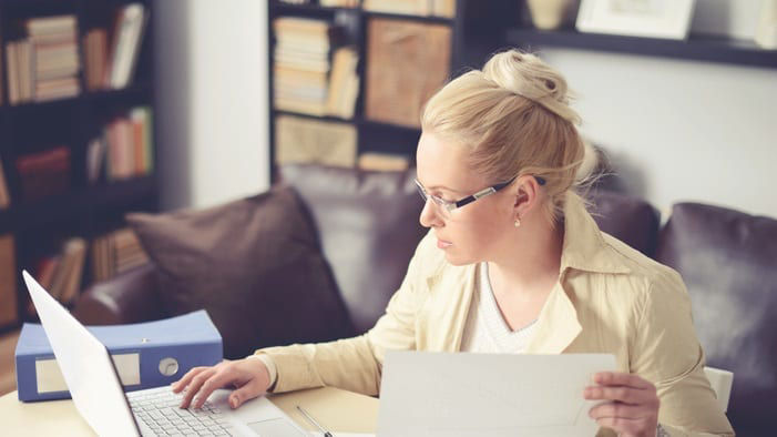 A woman working on her laptop at home.