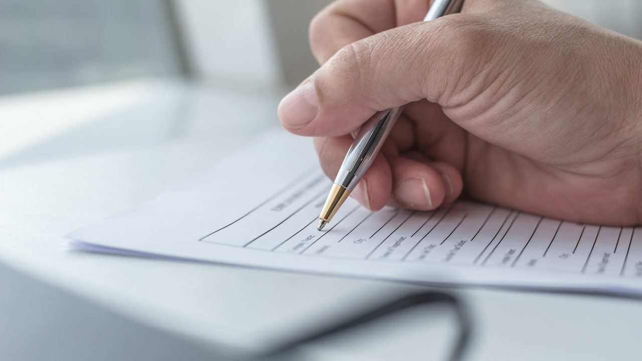 Person filling in form document doing paperwork