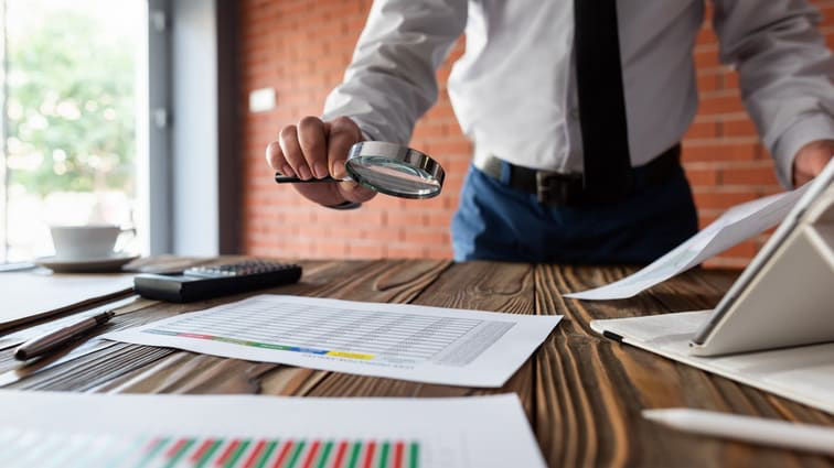 A businessman looking at documents on a desk.