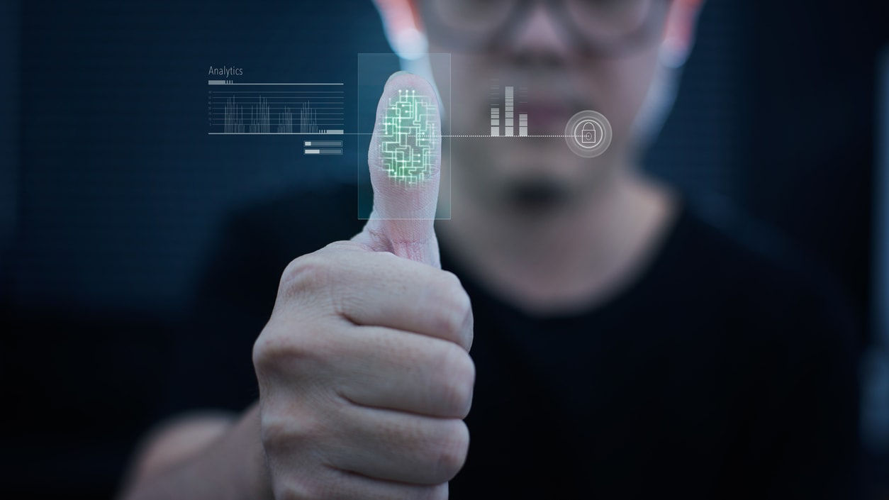 A man is giving a thumbs up in front of a computer screen.