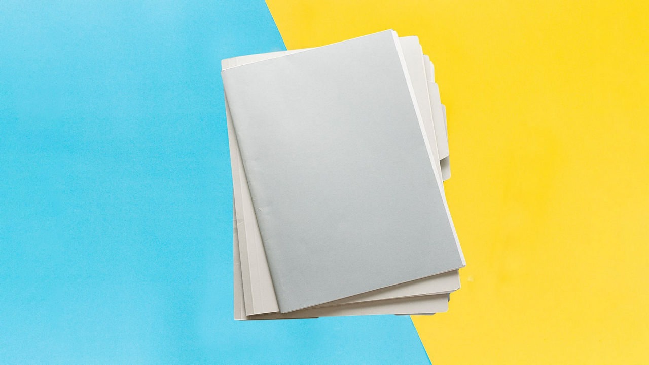 A stack of white paper on a yellow and blue background.