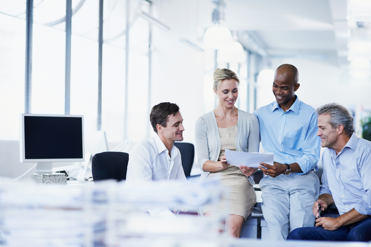 Shot of a group of businesspeople discussing paperwork in office