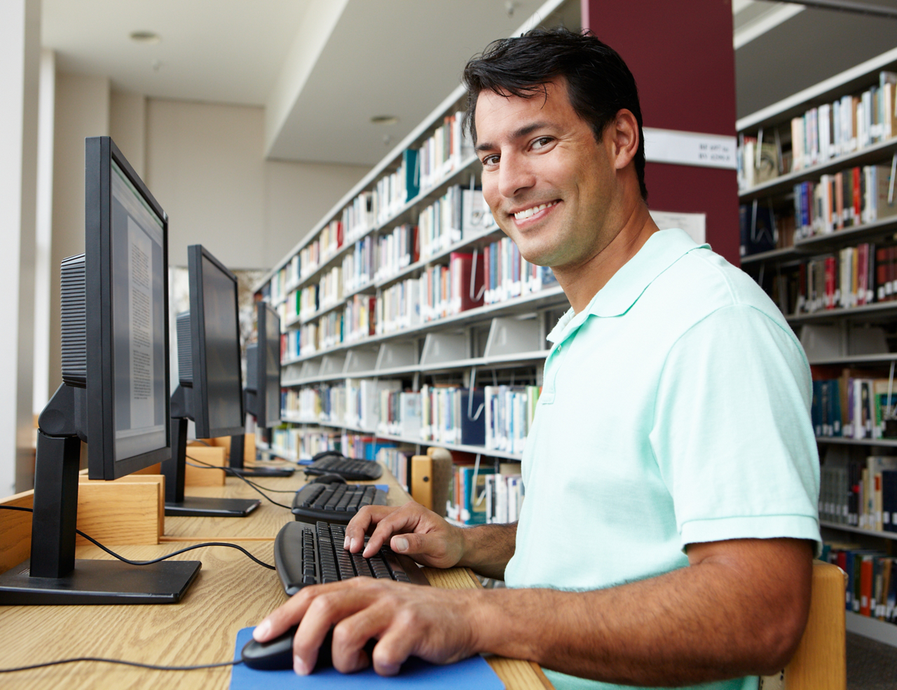 Man working on computer in library on his own