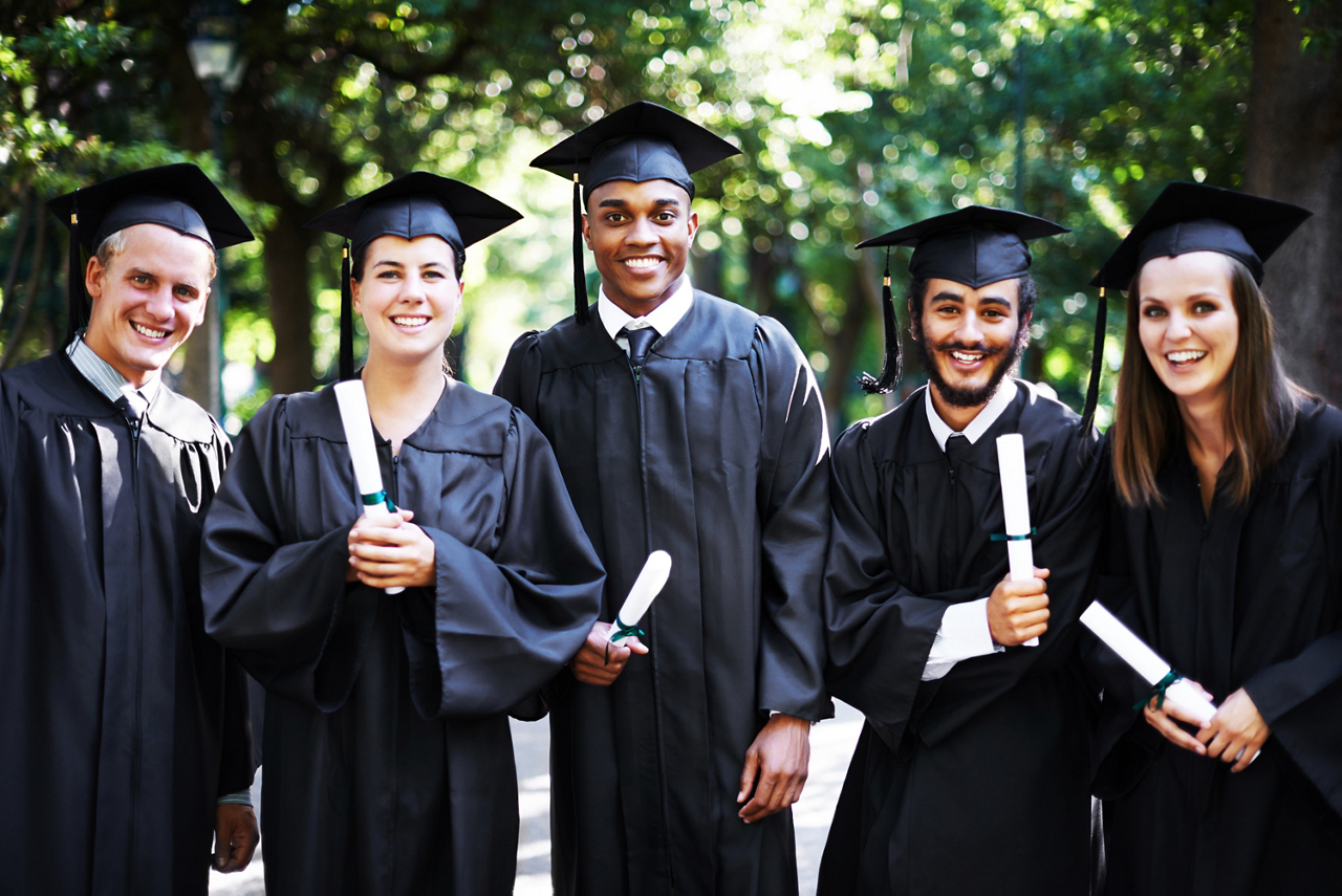Portrait of a group of happy students holding their diplomas on graduation day
