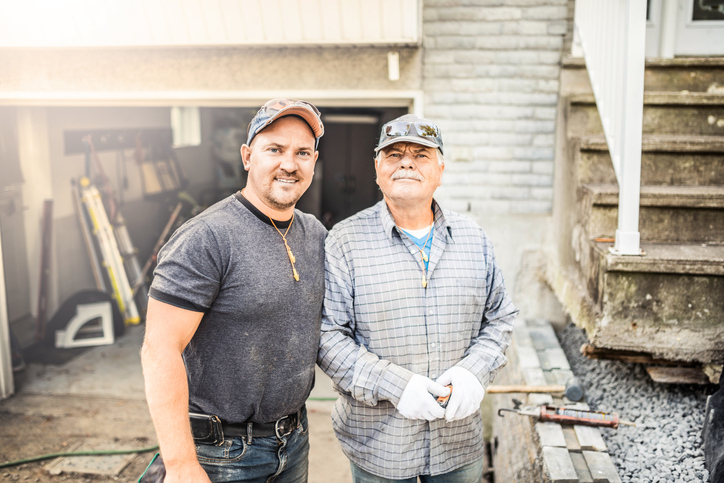 Senior father and his adult son renovating their house