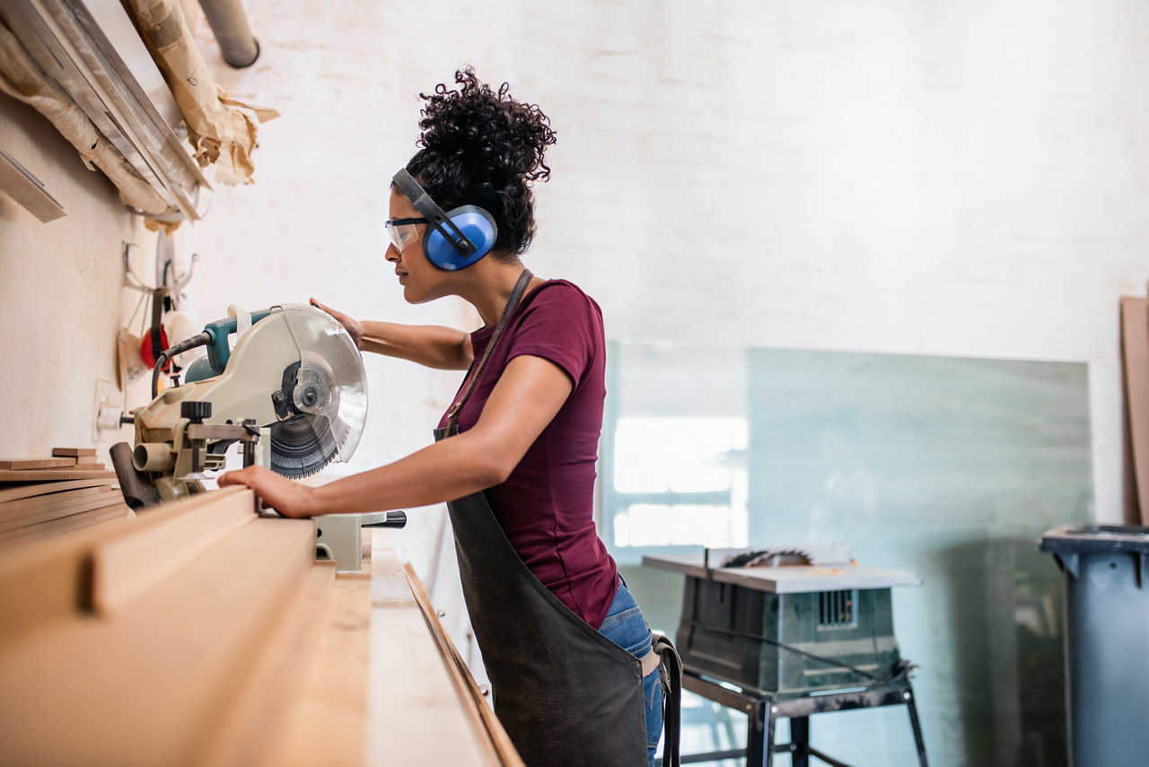 woman working wood shop headphones