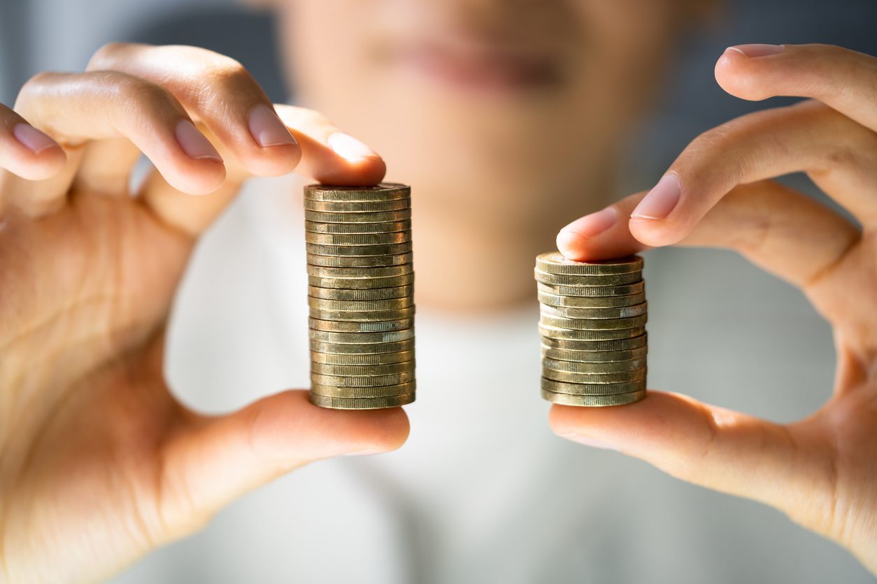 two stacks of coins, one bigger than the other -- signifying a pay gap