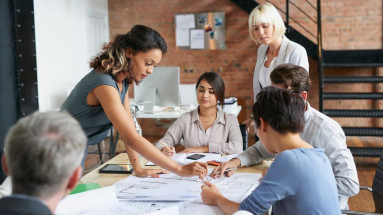 A group of business people working together in a meeting room.