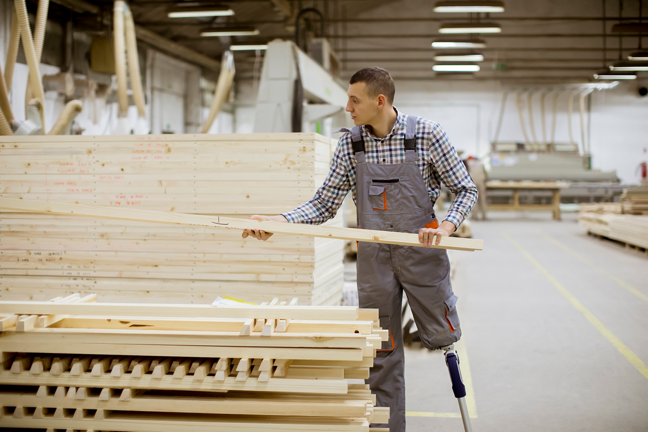 Man with a prosthetic leg in lumber mill