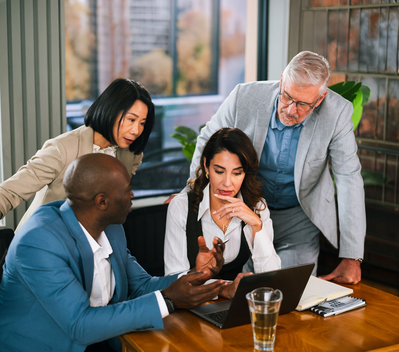 Woman, meeting and team at office in discussion, planning or review for project at eco friendly agency. People, group and talk with insight, sustainability or solution at climate consulting company