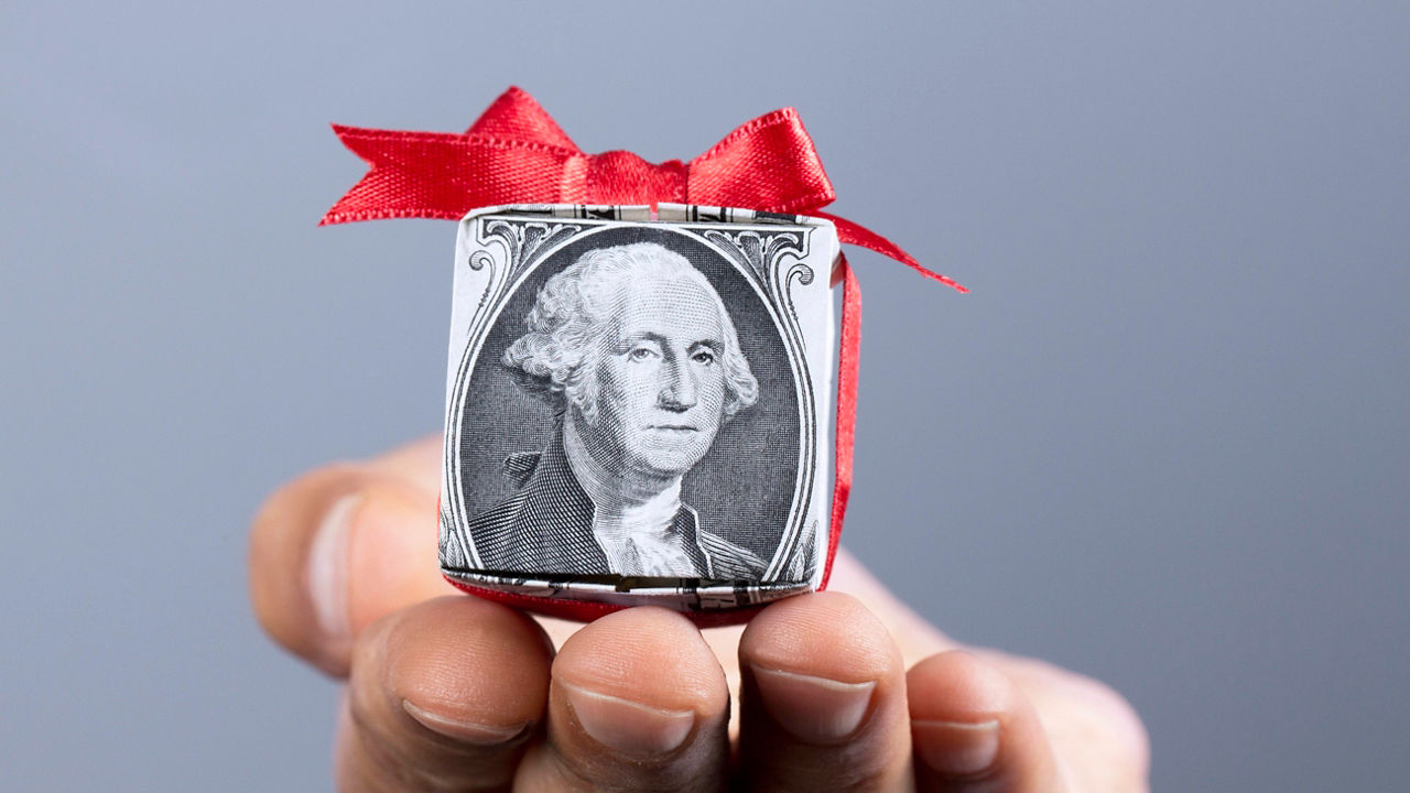 A hand holding a dollar bill with a picture of george washington.