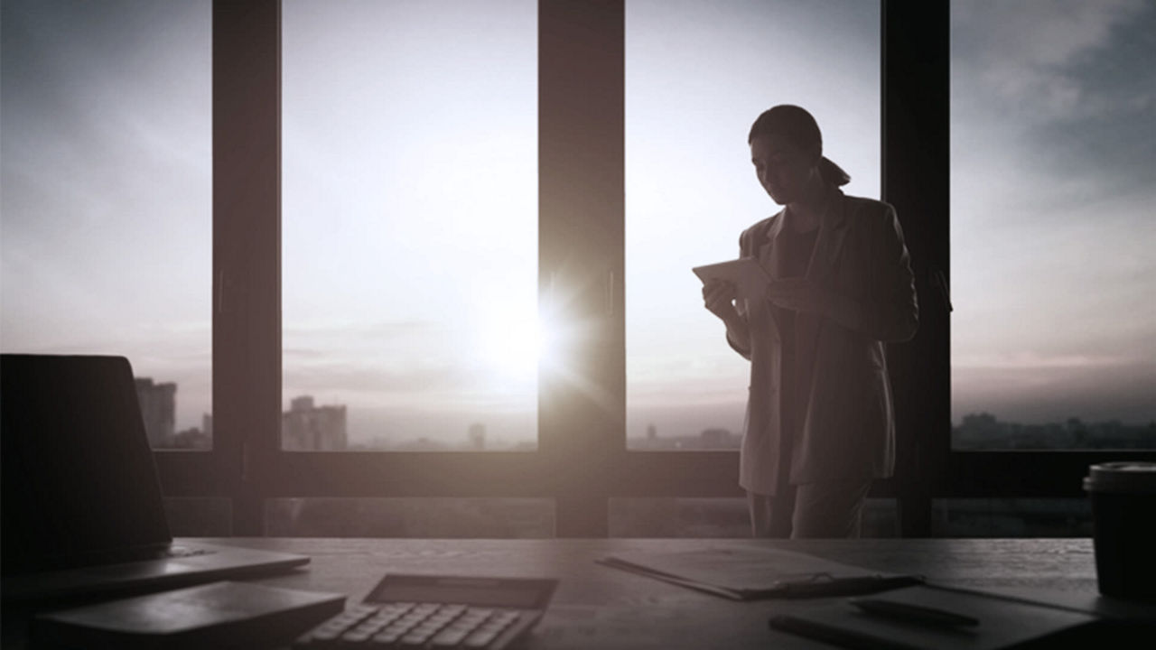 A silhouette of a woman standing in front of a window.