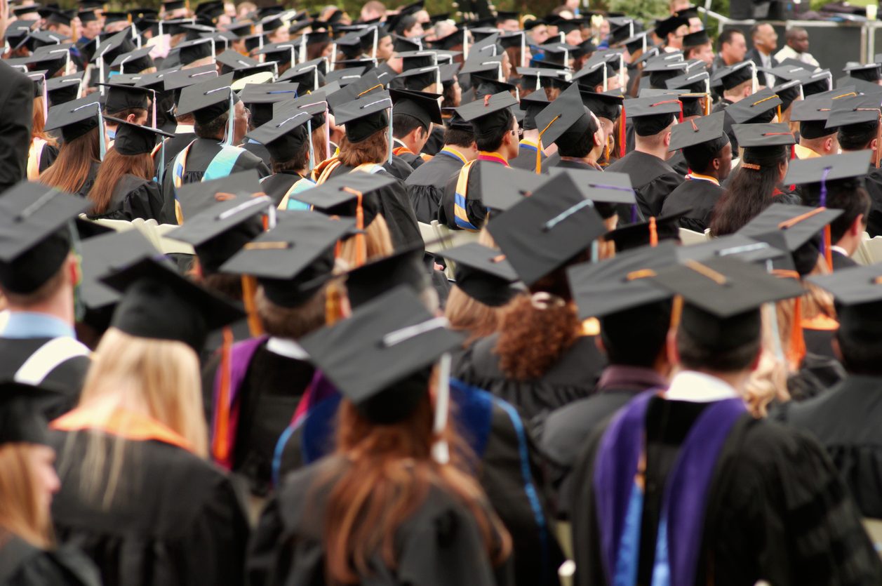 students wearing caps and gowns at a graduation ceremony