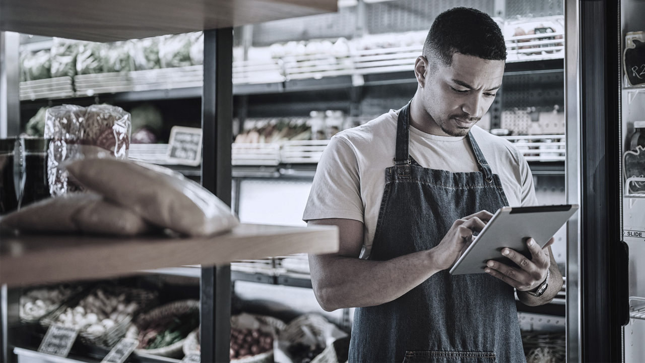 grocery worker tapping on his iPad