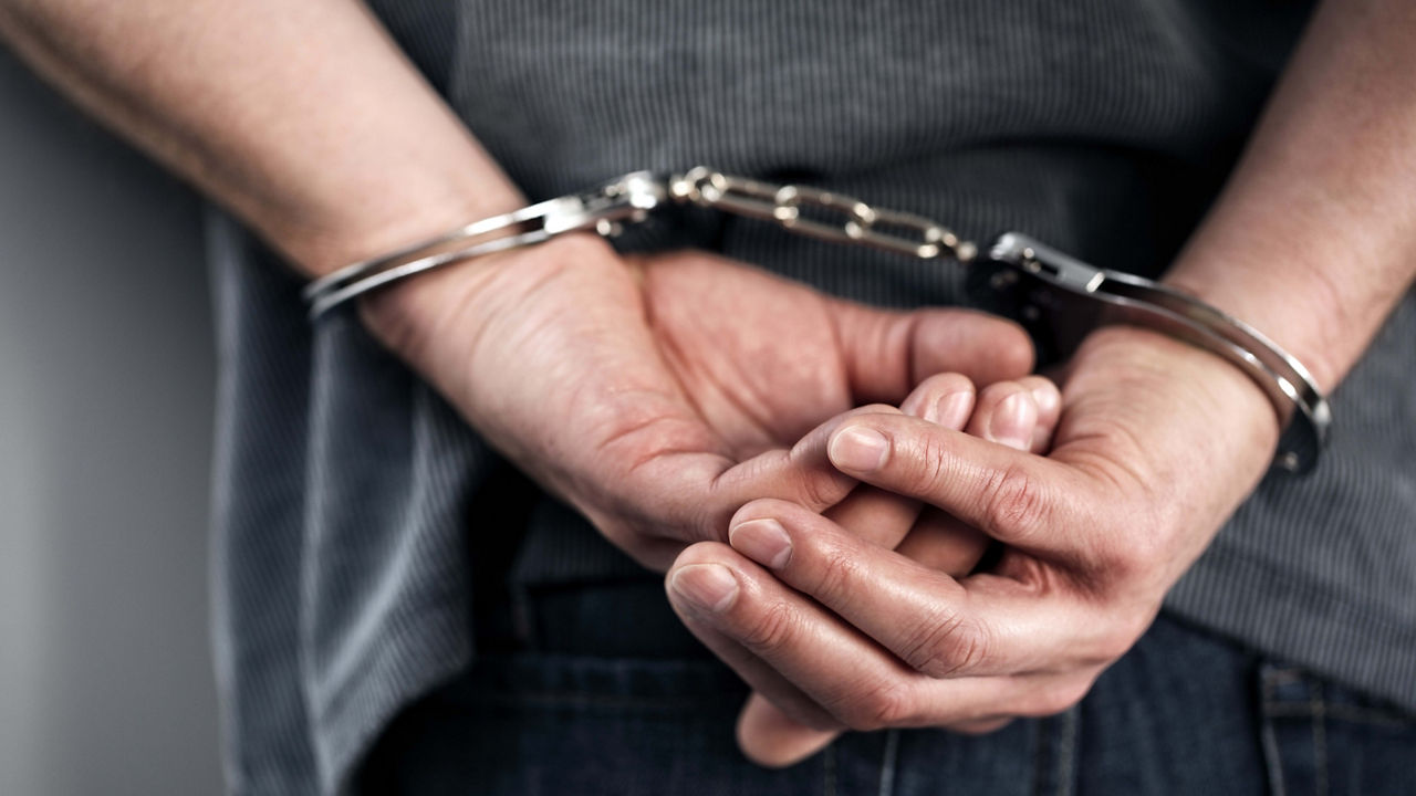 A man in handcuffs holding his hands.