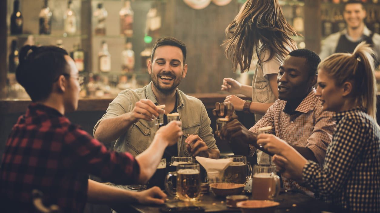 A group of people drinking beer at a bar.