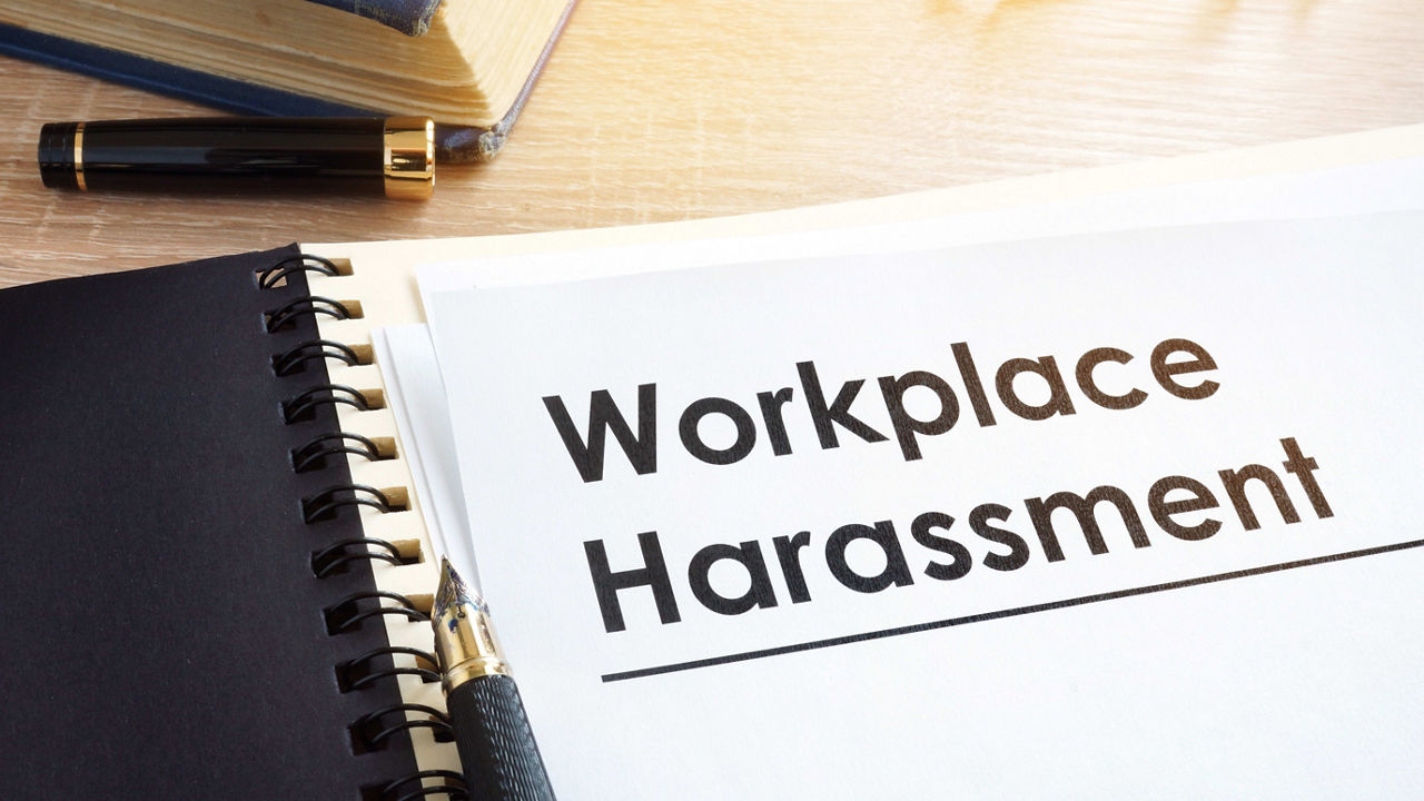 A notebook with the word workplace harassment on it.
