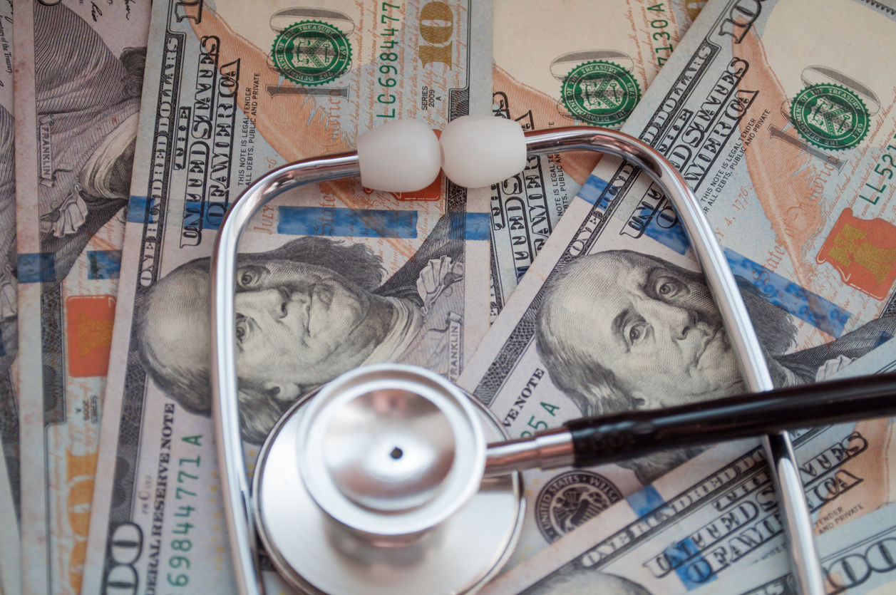stethoscope on a stack of paper money bills