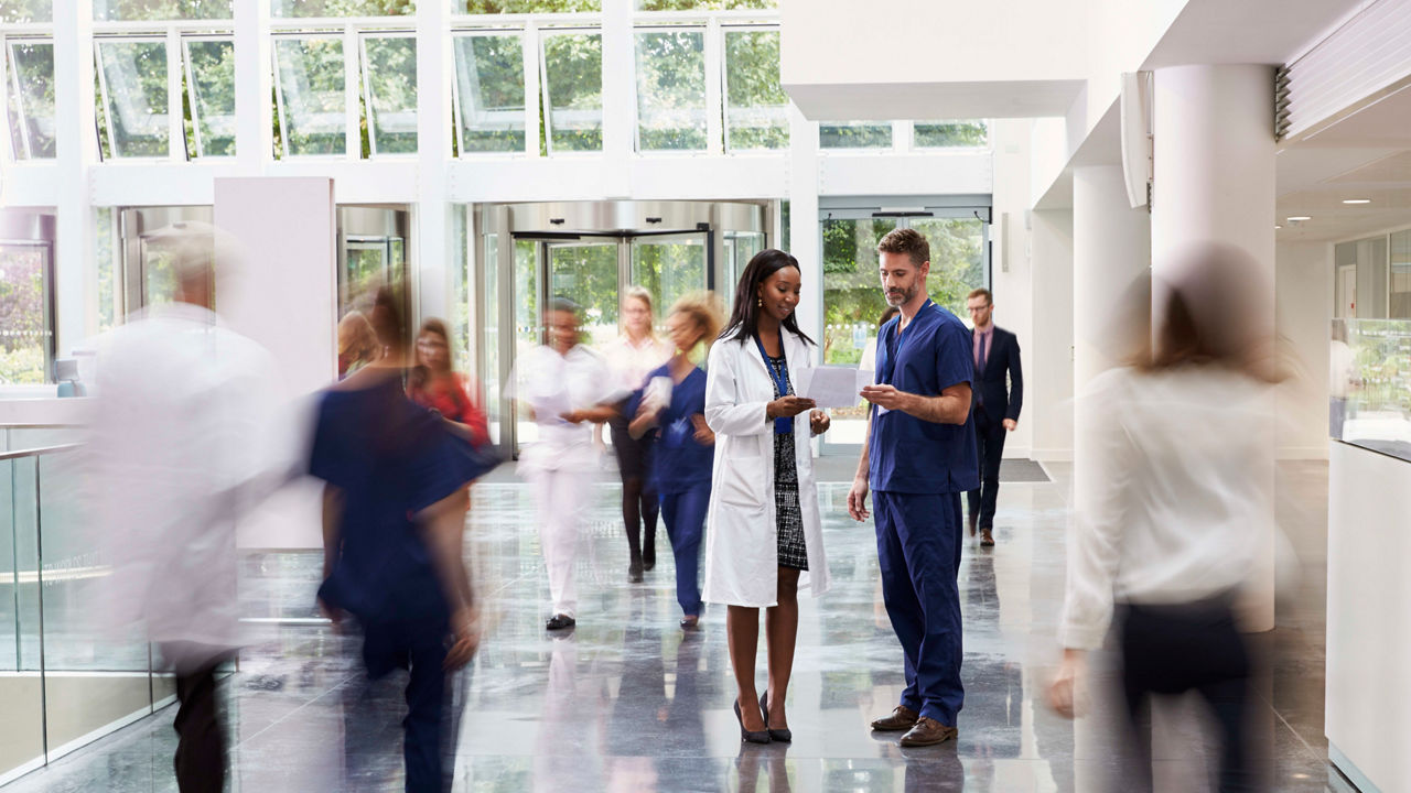 A group of people walking through a hospital hallway.