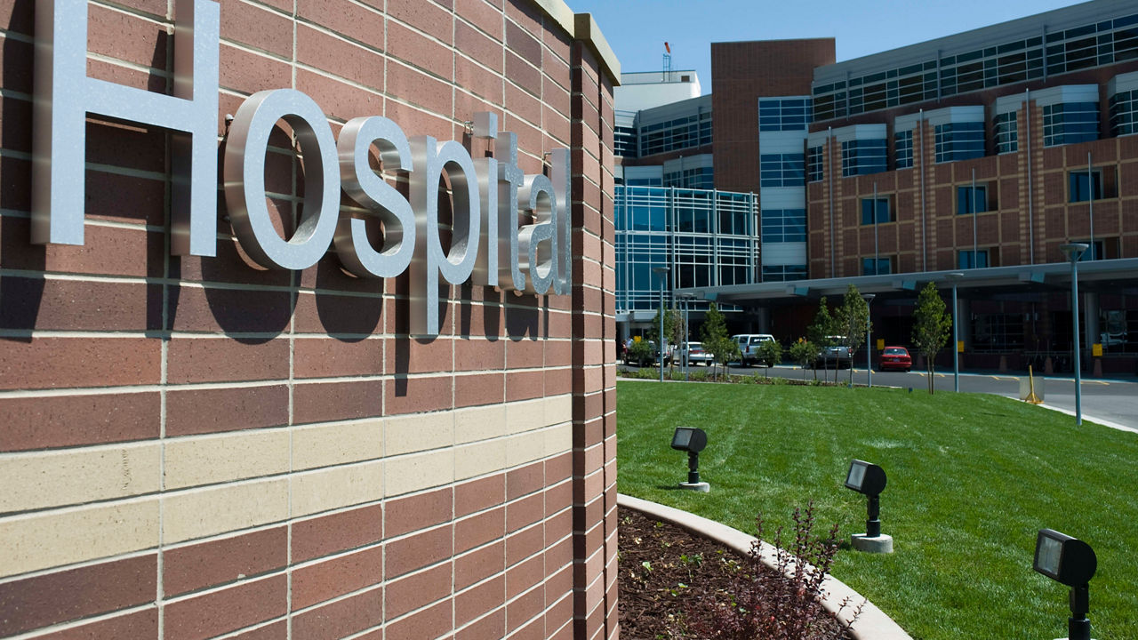 A hospital sign in front of a brick building.