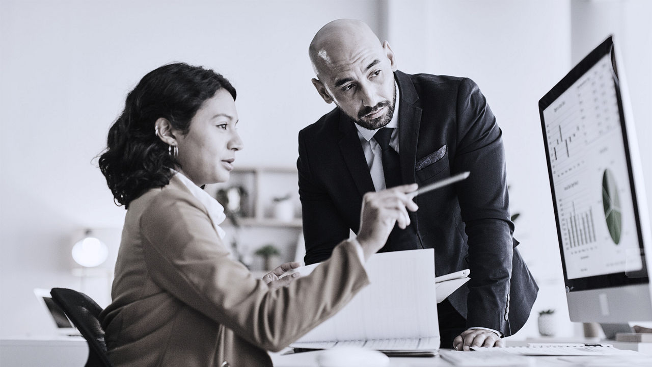Two coworkers looking at a computer screen.