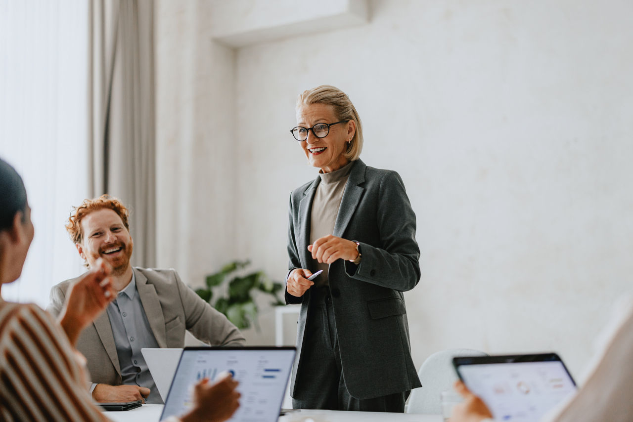 A group of business colleagues sharing a happy and engaged moment during a meeting in a modern office.
