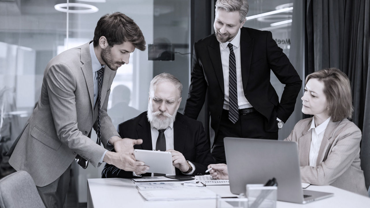 Four business leaders having a discussion at a table.