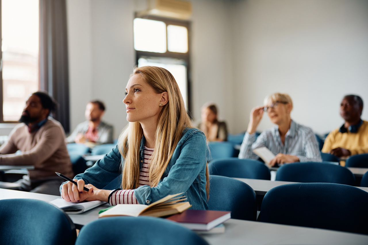 Mid adult woman attending education training course in the classroom.