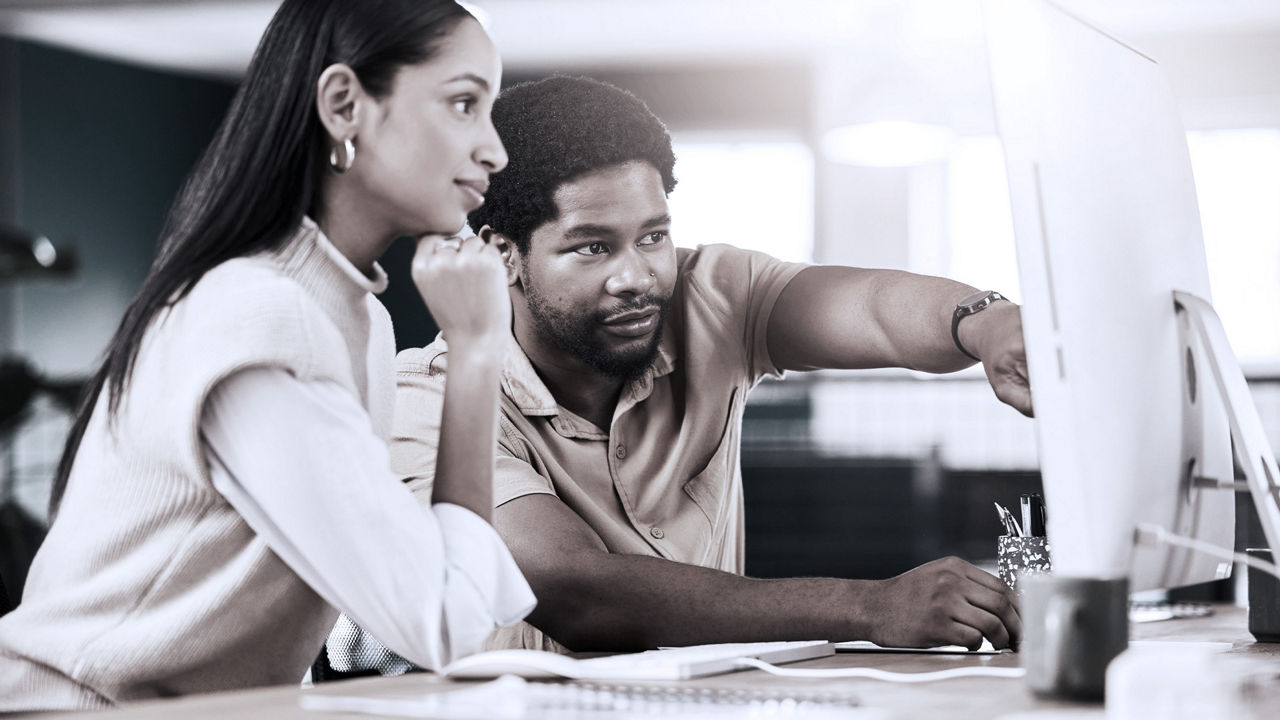 Two coworkers looking at a computer screen.
