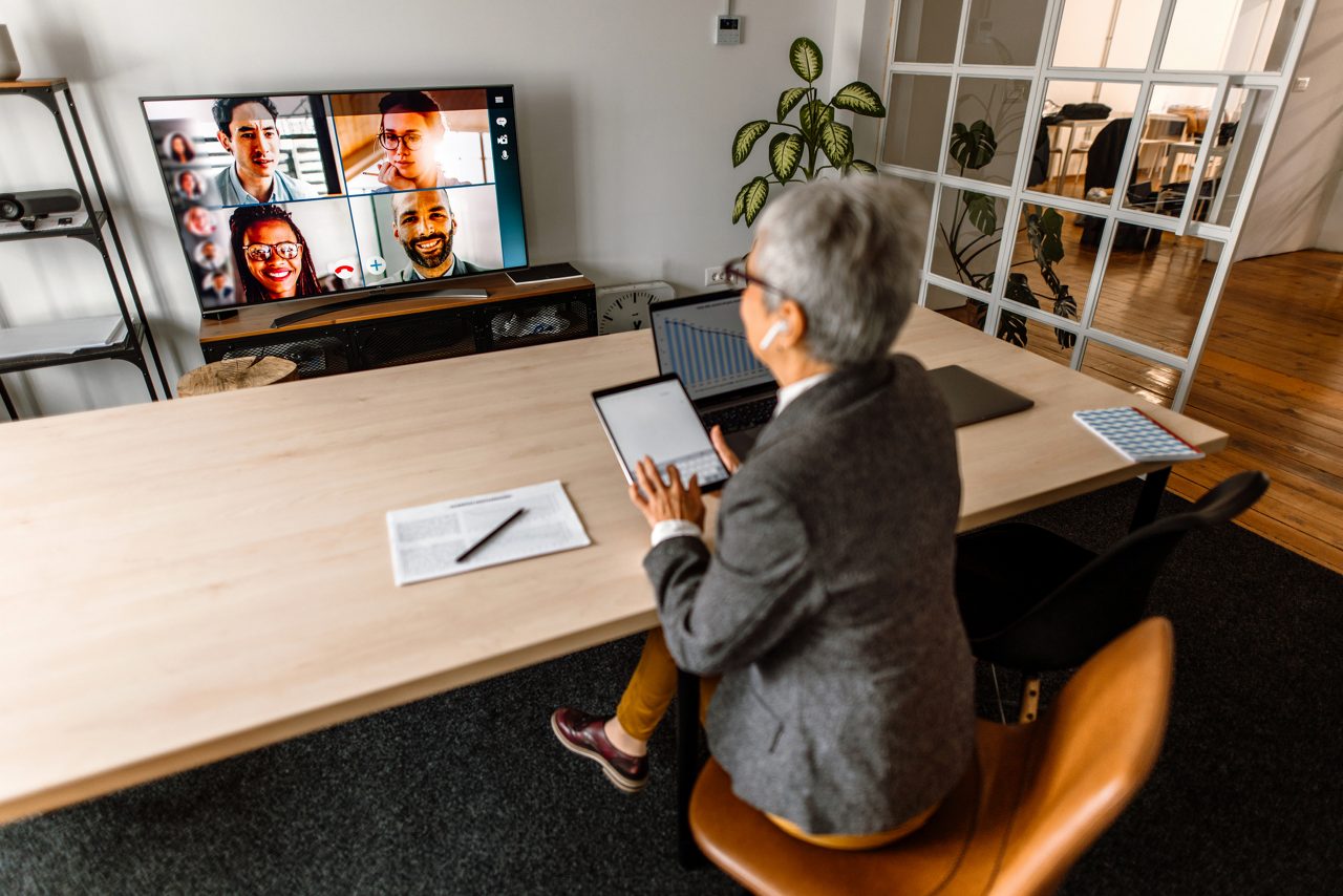 An employee in a business office joins an online meeting with colleagueses