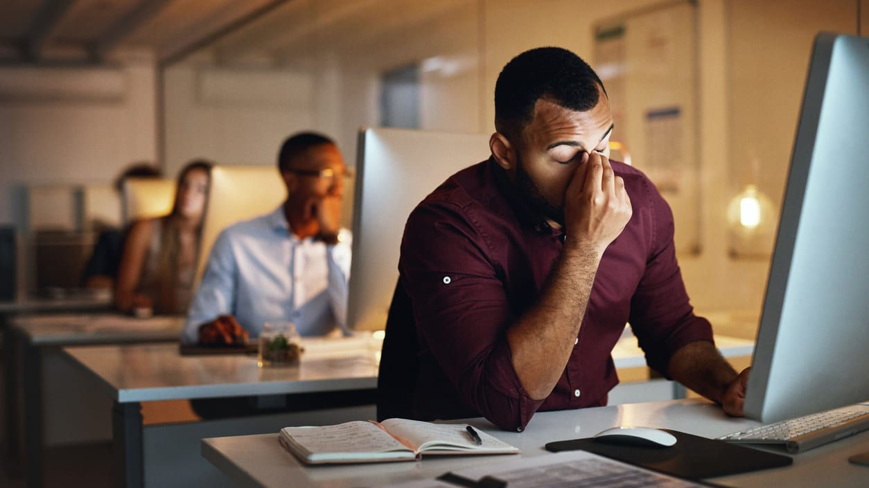 A group of people sitting in front of a computer.