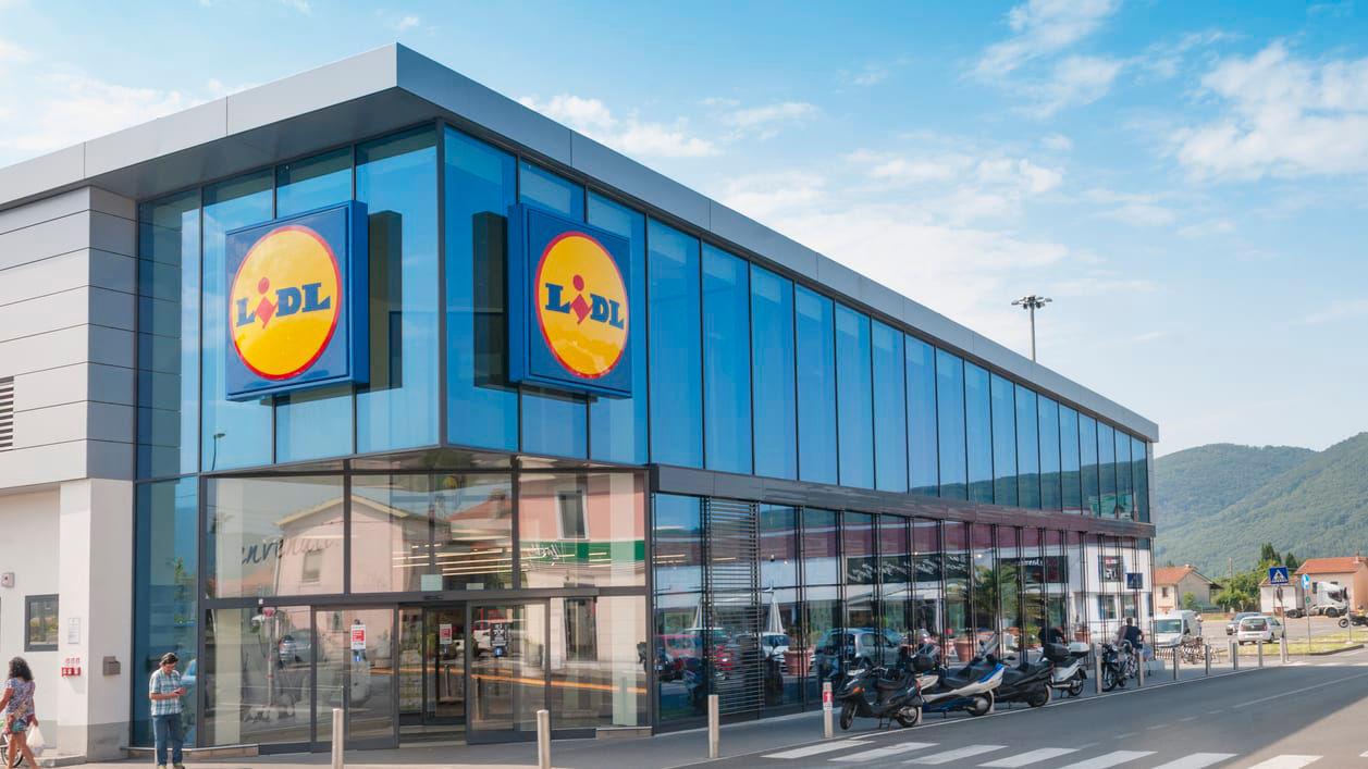 A large building with a lot of people walking in front of it.