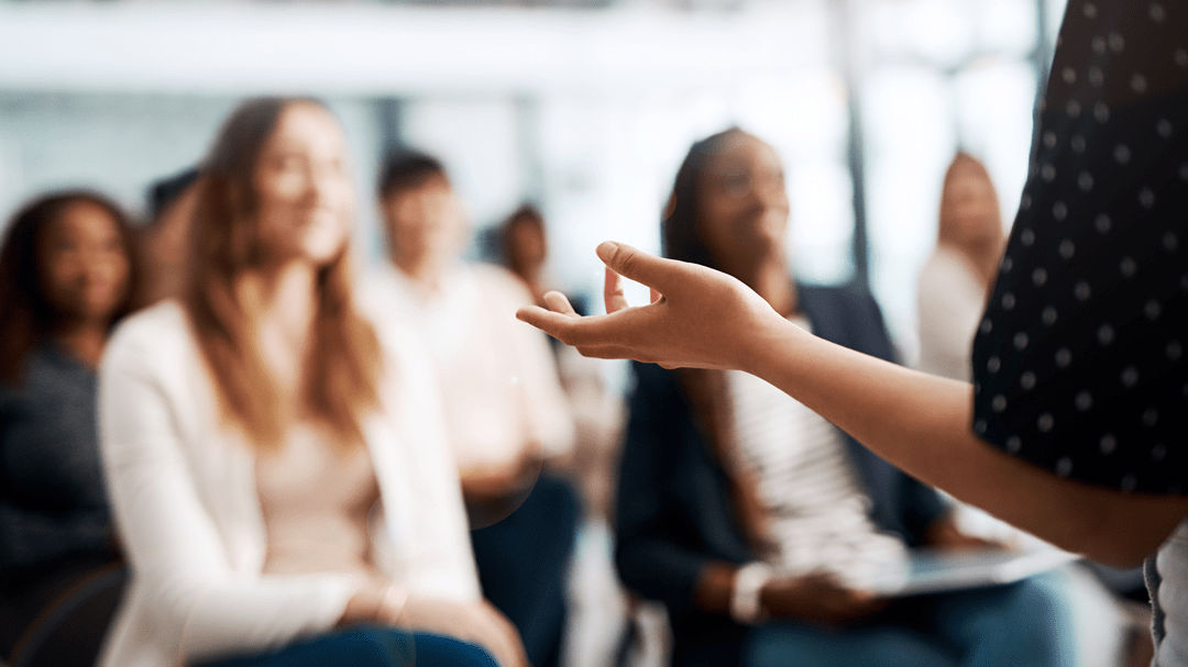 A woman is giving a presentation to a group of people.