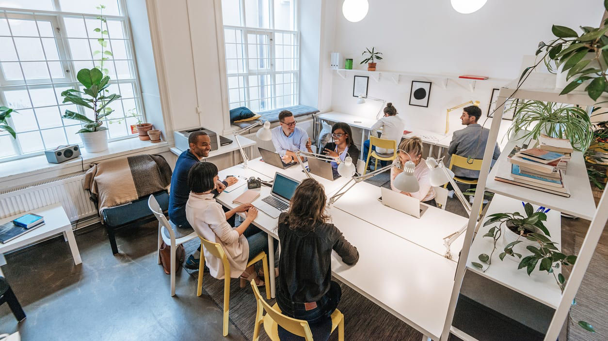 A group of people sitting around a table in an office.