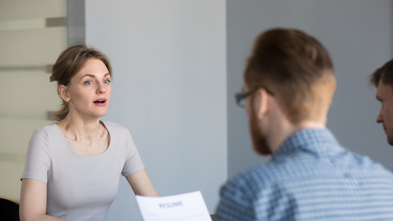 A woman is talking to a man in an office.