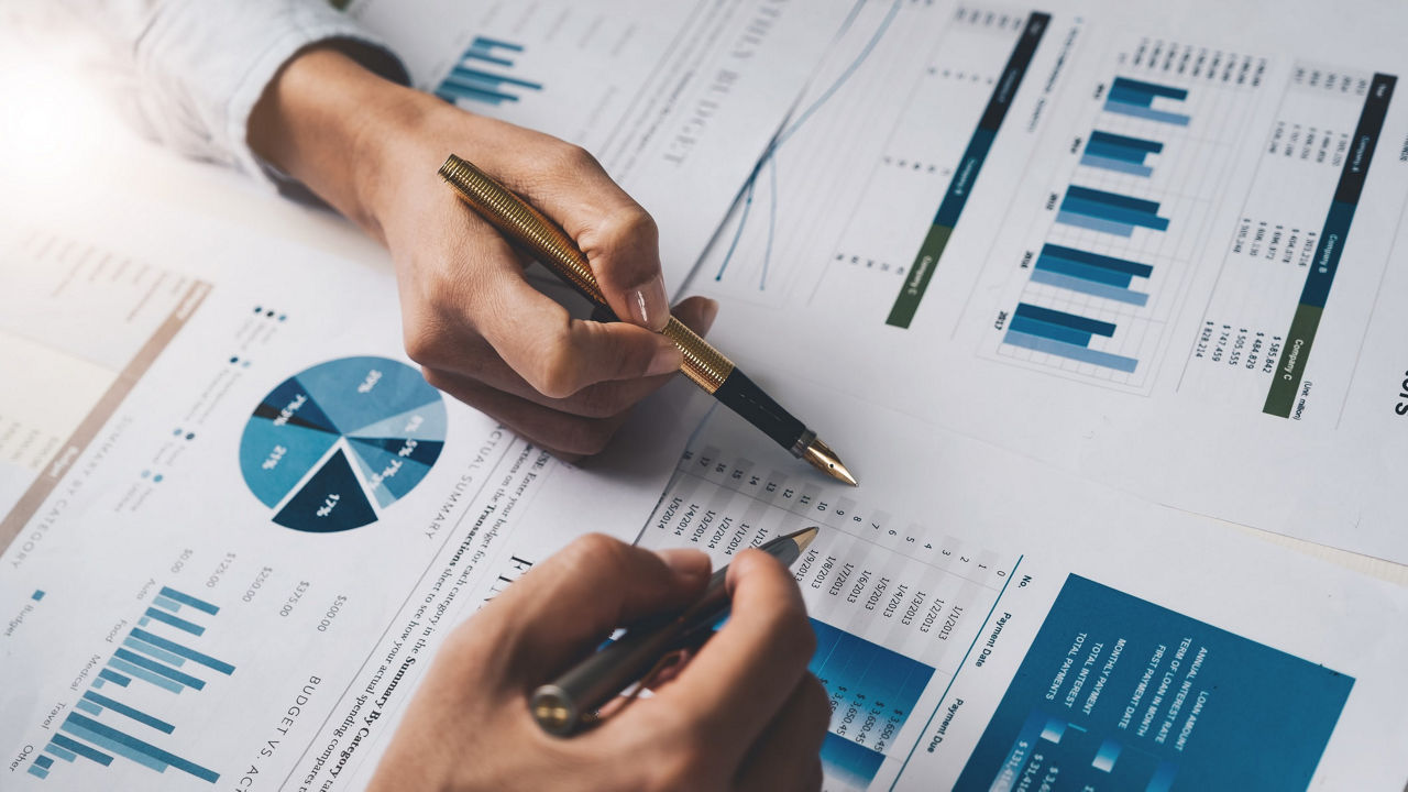 A group of business people looking at graphs on a table.