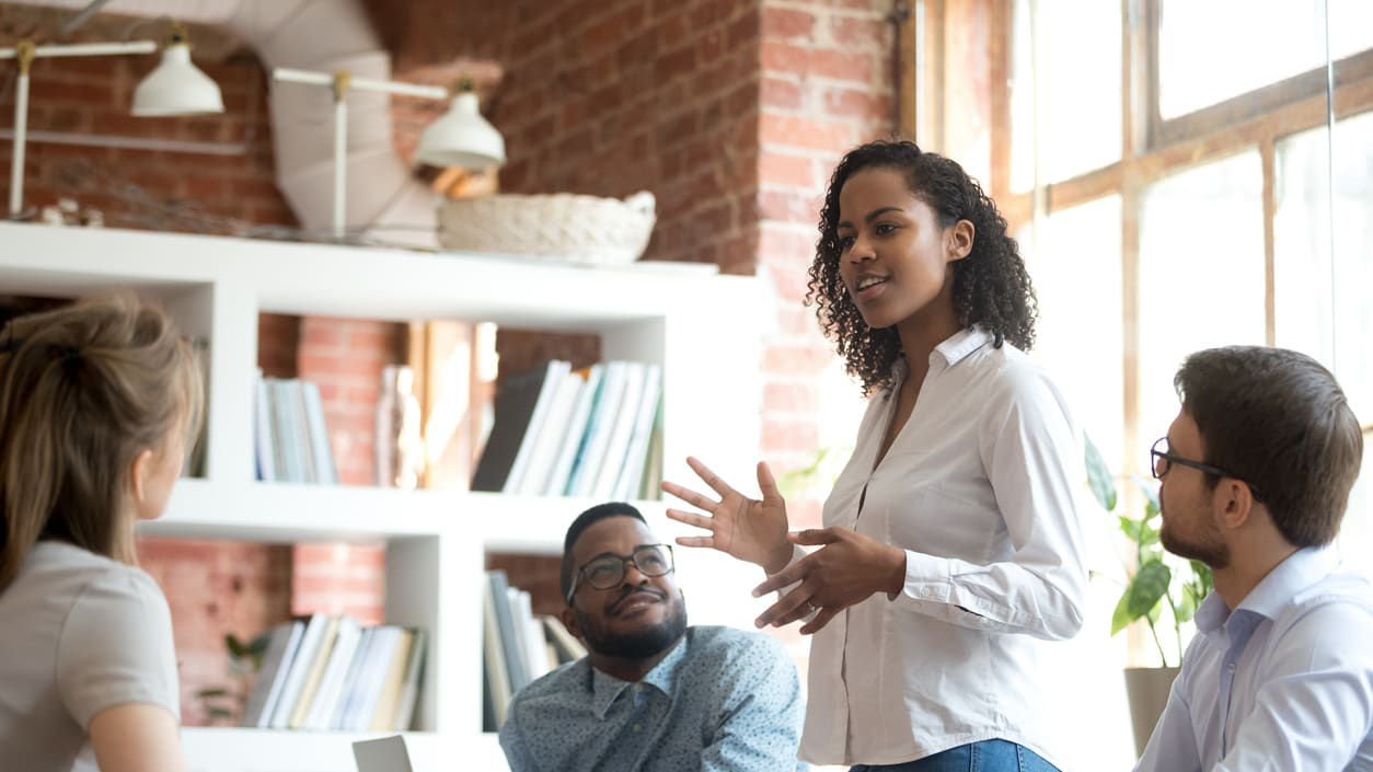A group of people sitting around a table in an office.