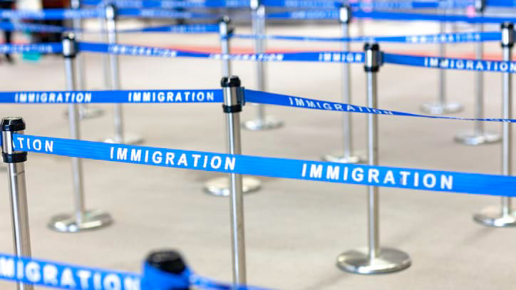 A line of blue tape with the word immigration written on it.