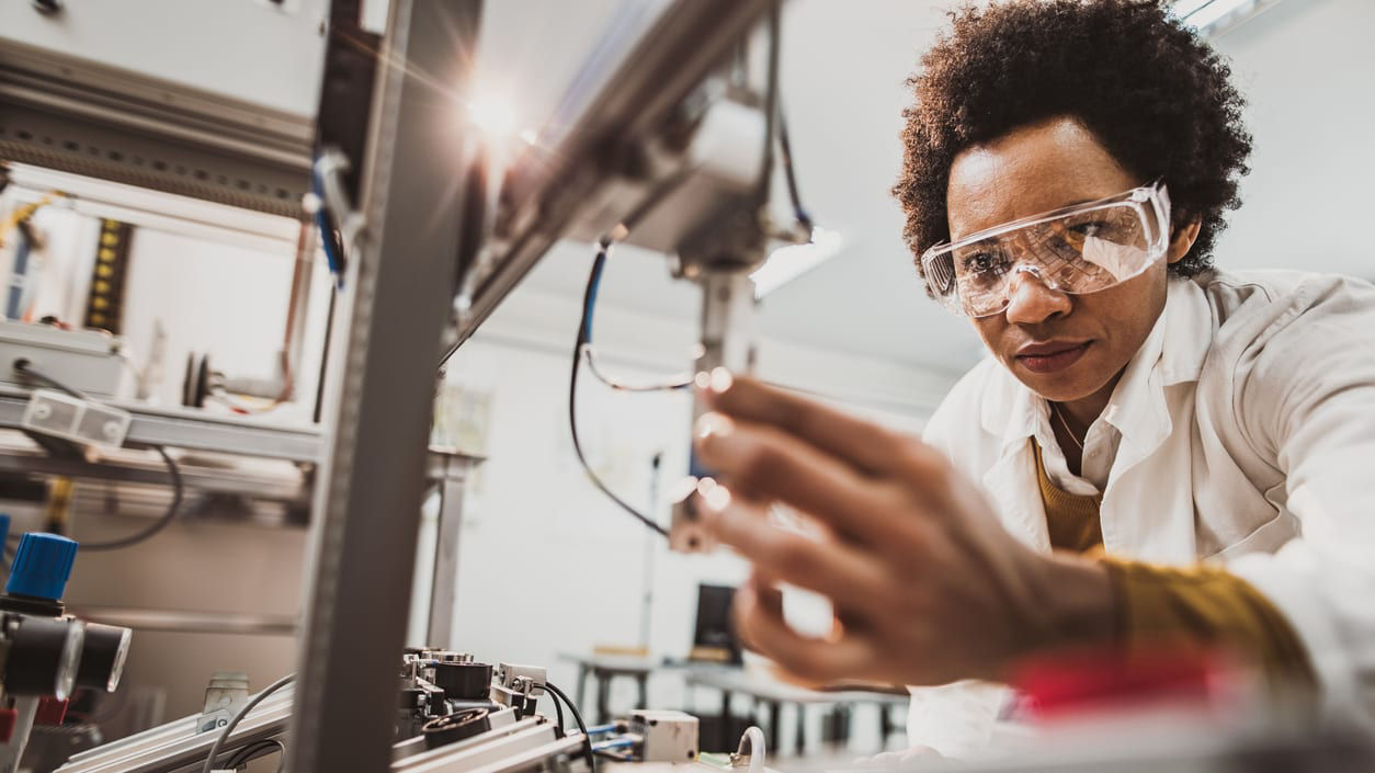 A woman is working on a machine in a laboratory.
