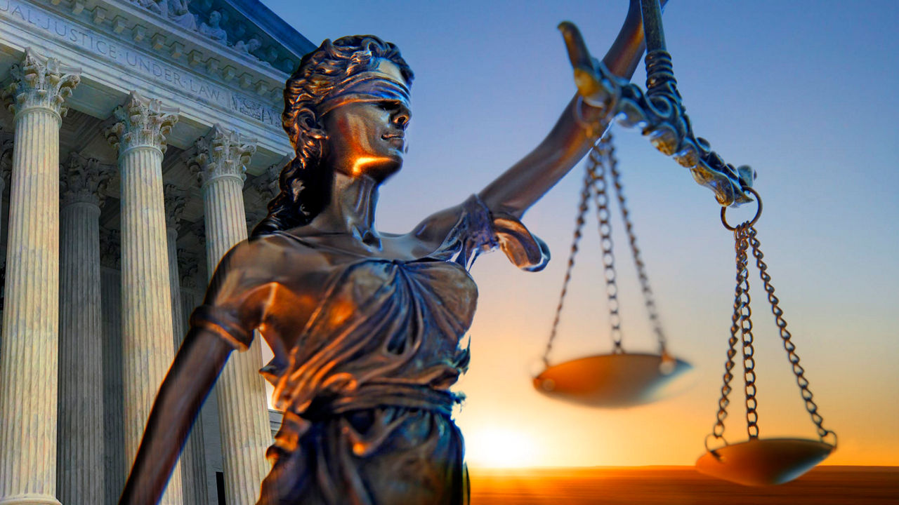 A statue of justice holding scales in front of the supreme court building.