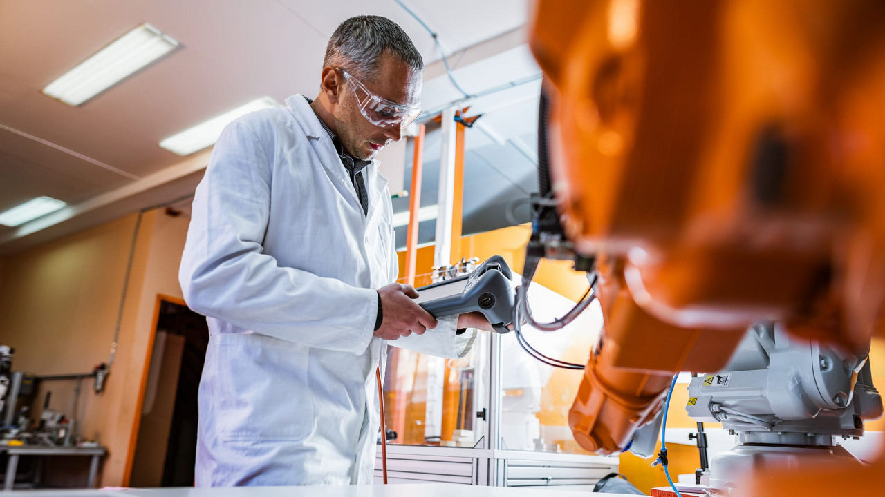A man is working with a robot in a laboratory.
