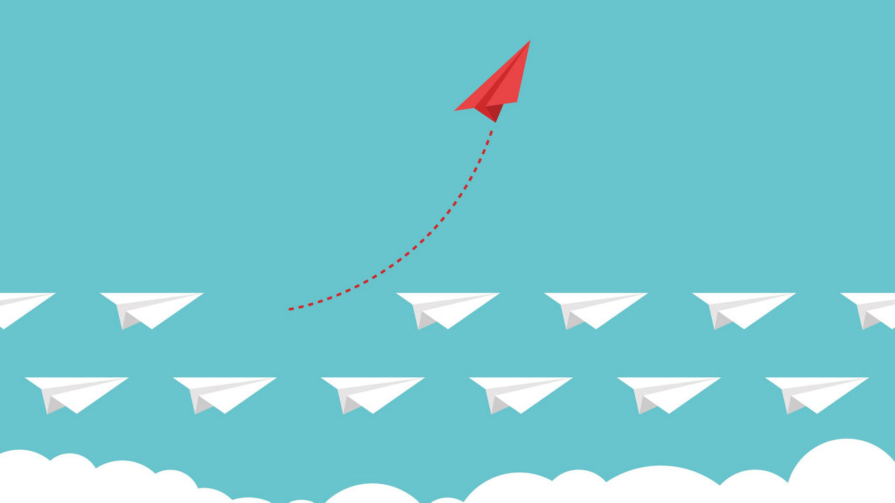 A group of paper airplanes flying in the sky.