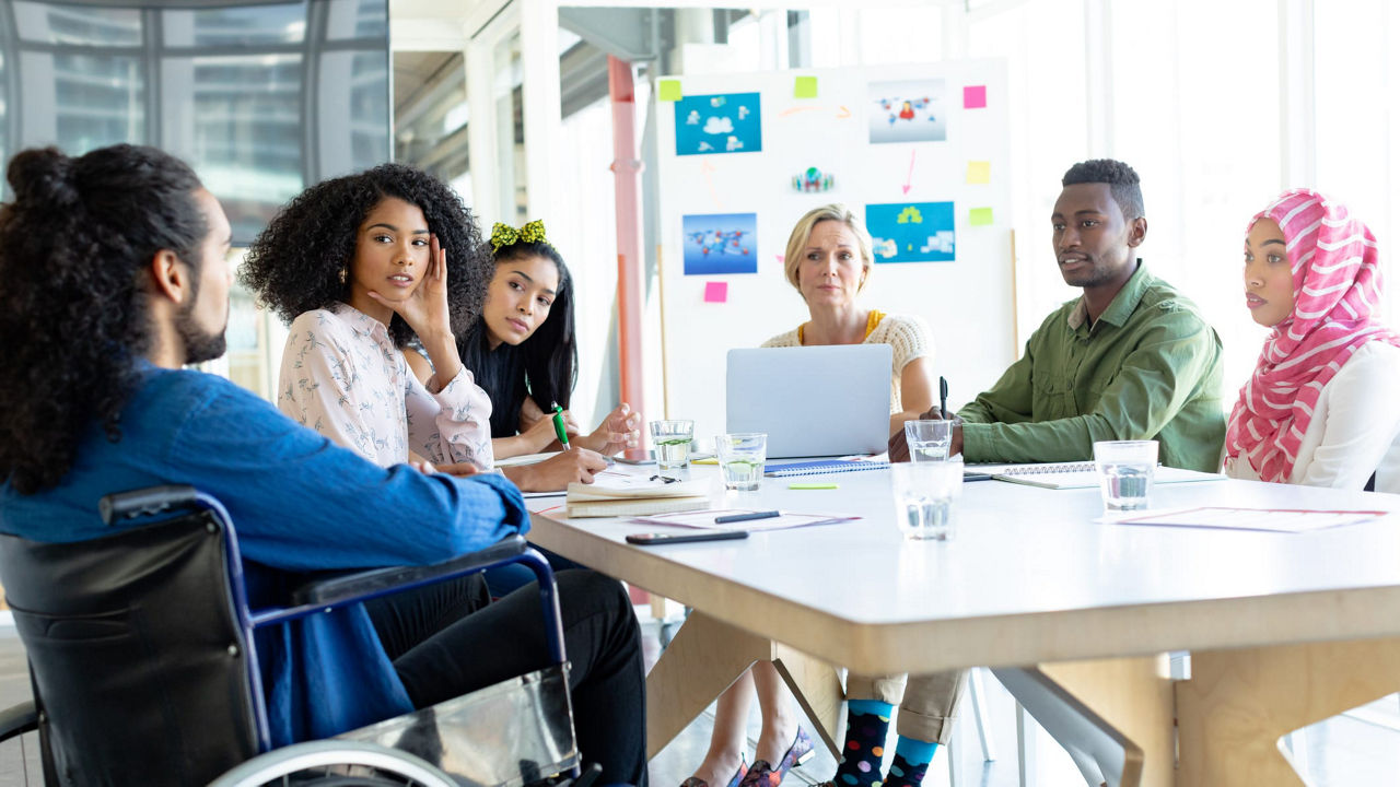 A group of people sitting around a table having a meeting