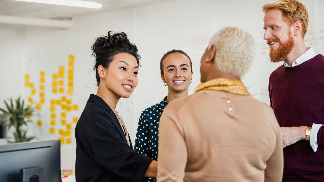 A group of people in an office talking to each other.