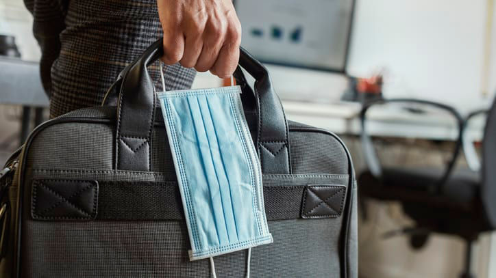 A man carrying a medical mask in a briefcase.
