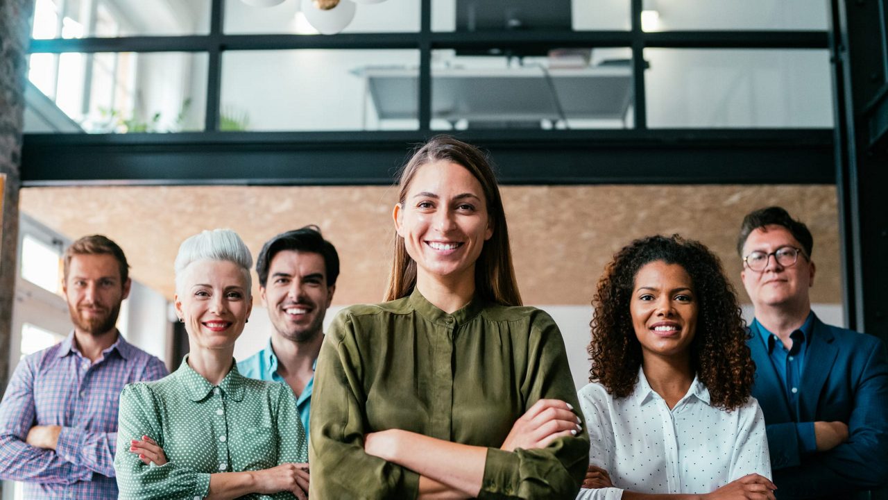 A group of business people standing together in an office.