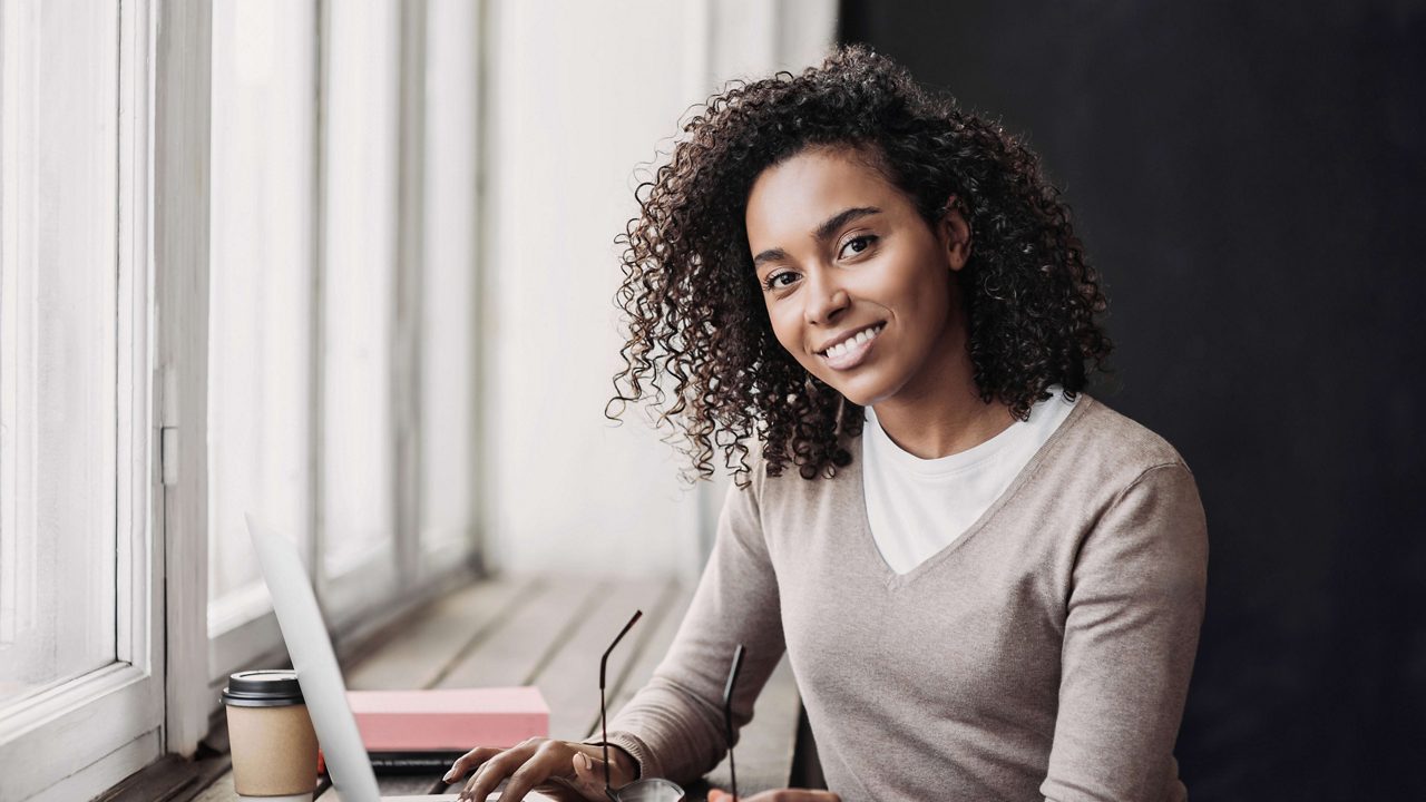 A young woman sitting at a desk with a laptop.