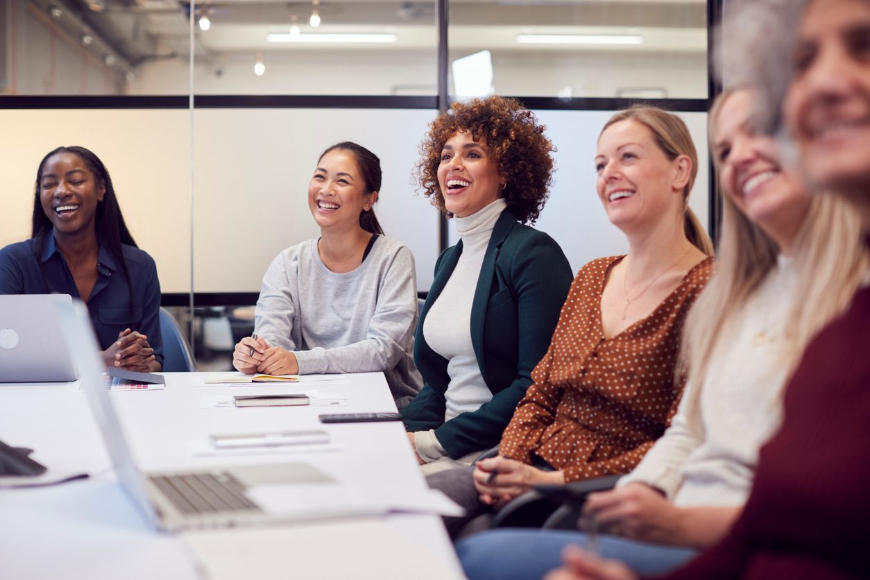 diverse group of women smiling and laughing at work